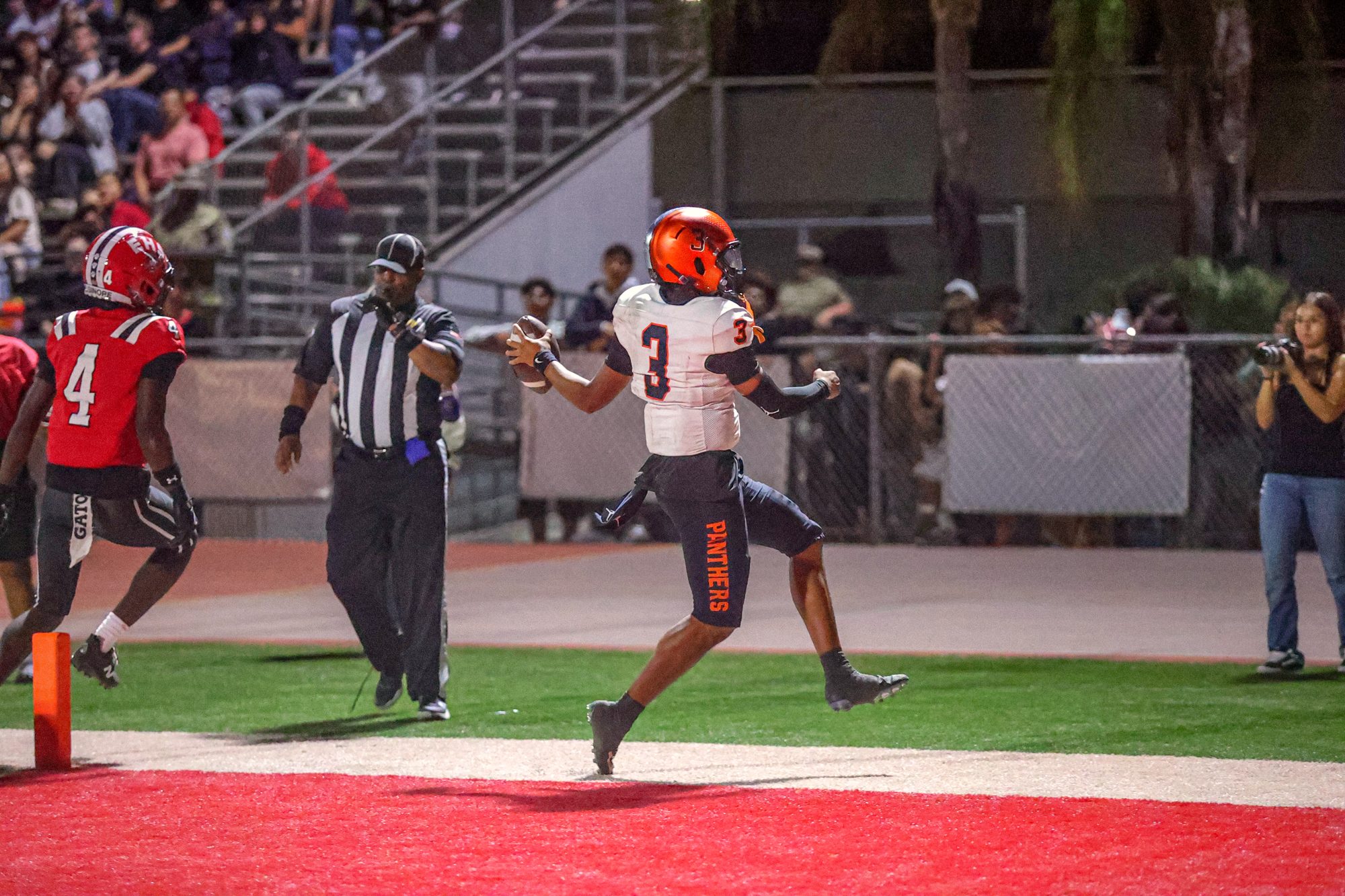 Orange Panthers #3 crossing the goal line as the official signals